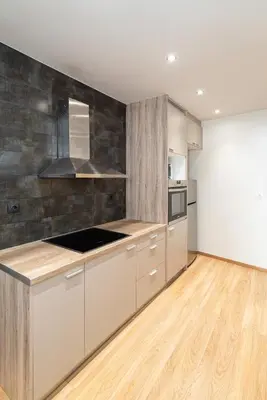 a kitchen with white cabinets and wood floors at Athens Dimora Di Aristotele 3 in Athens