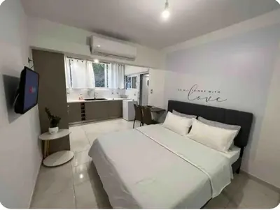 a bedroom with a large white bed and a kitchen at A warm home near the center 2 in Athens