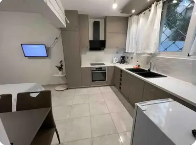 a large kitchen with a sink and a window at A warm home near the center 2 in Athens