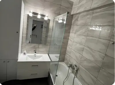 a bathroom with a sink and a shower with a mirror at A warm home near the center 2 in Athens