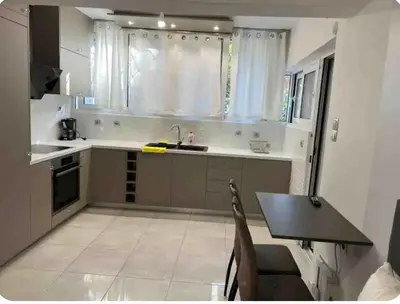 a kitchen with a sink and a table and a window at A warm home near the center 2 in Athens