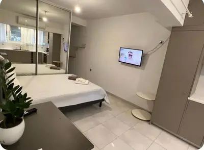 a hospital room with a bed and a tv on the wall at A warm home near the center 2 in Athens