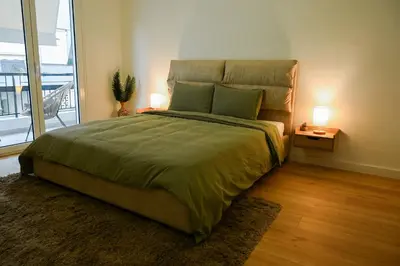a bedroom with a large bed and a large window at Portside Residence Piräus in Piraeus