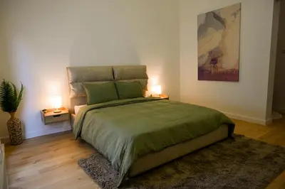 a bedroom with a large bed with two lamps at Portside Residence Piräus in Piraeus