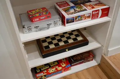 a book shelf filled with toys and a chessboard at Portside Residence Piräus in Piraeus