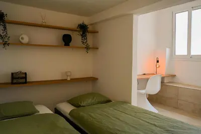 a bedroom with two beds and a window at Portside Residence Piräus in Piraeus