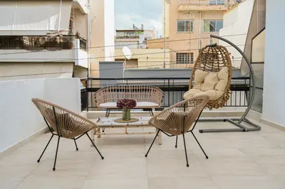 a balcony with two chairs and a table on a balcony at Portside Residence Piräus in Piraeus