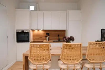 a kitchen with white cabinets and a table and chairs at Portside Residence Piräus in Piraeus
