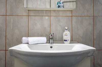 a bathroom sink with a bottle of soap on it at Kastella Sea Breeze Studio by ΜΡS in Piraeus