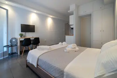 a bedroom with a bed and a desk and a television at Kastella Sea Breeze Studio by ΜΡS in Piraeus