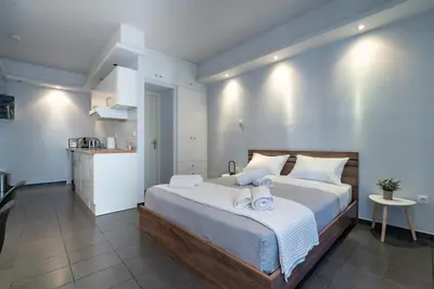 a bedroom with a large bed and a kitchen at Kastella Sea Breeze Studio by ΜΡS in Piraeus