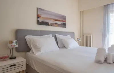 a bed with white sheets and pillows in a bedroom at ANDIE Agios Eleftherios in Athens