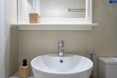 a bathroom with a sink and a mirror and a toilet at Authentic Athens Living In Zografou by ΜΡS in Athens