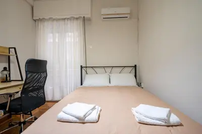 a bedroom with a bed and a desk and a chair at Authentic Athens Living In Zografou by ΜΡS in Athens