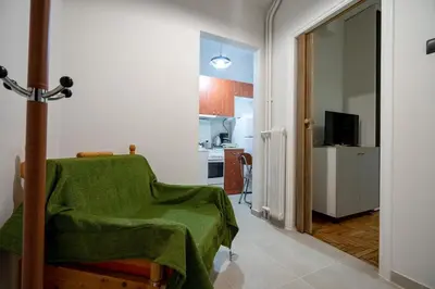 a living room with a green blanket on a chair at Authentic Athens Living In Zografou by ΜΡS in Athens