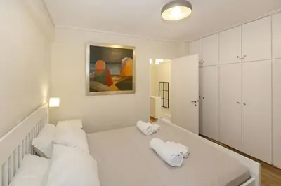 a white bedroom with white pillows on a bed at Riviera Garden House in Athens