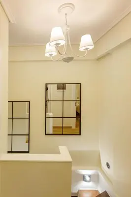 a bathroom with a mirror and a chandelier at Riviera Garden House in Athens