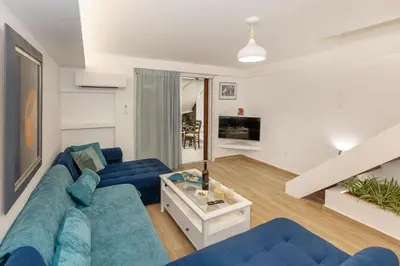 a living room with a blue couch and a table at Riviera Garden House in Athens