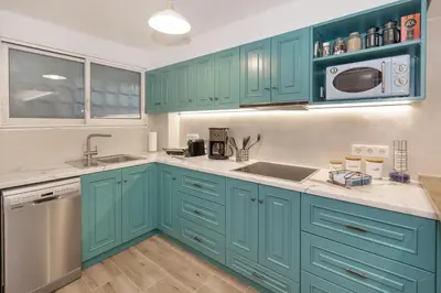 a kitchen with blue cabinets and a sink at Riviera Garden House in Athens