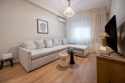 a living room with a white couch and a television at Acropolis Boutique Retreat in Koukaki Area Athens in Athens