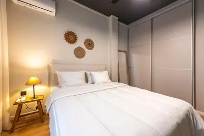 a bedroom with a large white bed and a lamp at Acropolis Boutique Retreat in Koukaki Area Athens in Athens