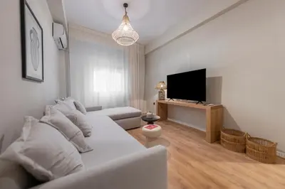 a living room with a couch and a flat screen tv at Acropolis Boutique Retreat in Koukaki Area Athens in Athens