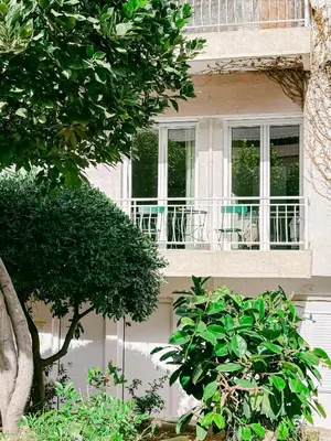 a building with a balcony with a tree in front of it at Spacious 2BR house in Nea Smyrni in Athens