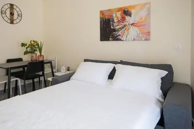 a bedroom with a bed and a table and a painting at ANDIE Athens Koukaki in Athens