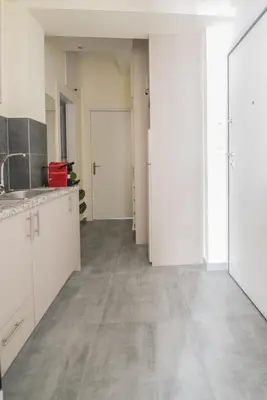 an empty kitchen with white cabinets and a hallway at ANDIE Athens Koukaki in Athens