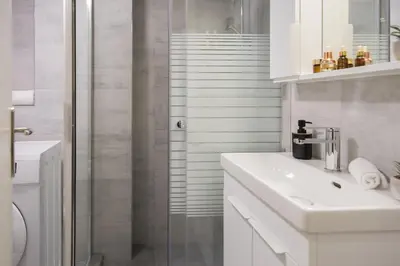 a white bathroom with a shower and a sink at ANDIE Athens Koukaki in Athens