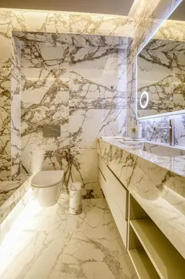 a marble bathroom with a toilet and a sink at The Canopy Loft, A Curated 5-Star Experience in Athens
