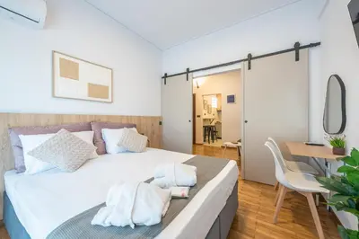 a bedroom with a bed and a table and a desk at Prime City Stay by Cloudkeys in Athens