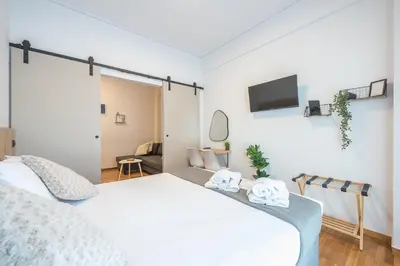 a bedroom with a bed and a tv on the wall at Prime City Stay by Cloudkeys in Athens