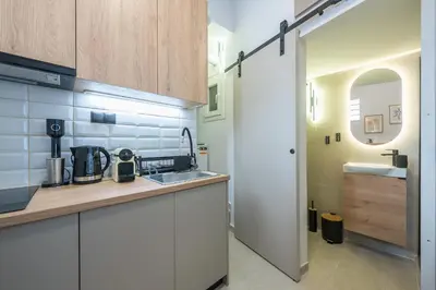 a kitchen with white cabinets and a sink at Prime City Stay by Cloudkeys in Athens