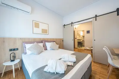 a bedroom with a large white bed with a table and chairs at Prime City Stay by Cloudkeys in Athens