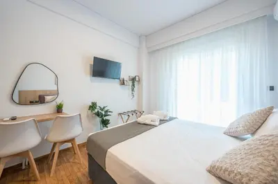 a bedroom with a bed and a desk and a mirror at Prime City Stay by Cloudkeys in Athens