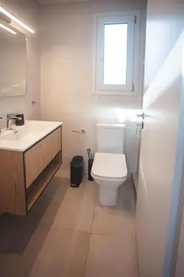 a bathroom with a toilet and a sink and a window at Zeno Apartments Athens in Athens