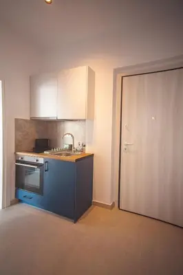a kitchen with a sink and a stove and a door at Zeno Apartments Athens in Athens