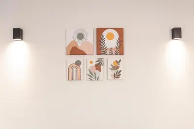 two lights on a white wall with illustrations of plants at Zeno Apartments Athens in Athens
