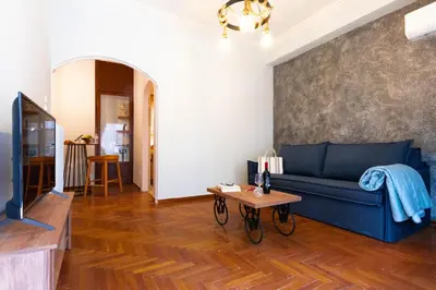 a living room with a blue couch and a table at DP Homes Acropolis Promenade in Athens