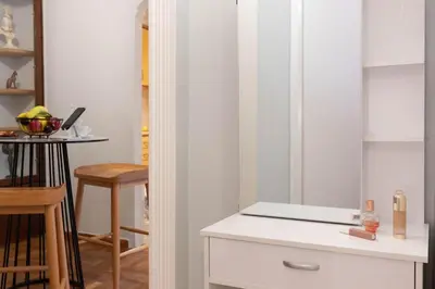 a kitchen with white cabinets and a table at DP Homes Acropolis Promenade in Athens