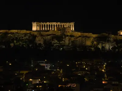 a building on top of a hill at night at DP Homes Acropolis Promenade in Athens