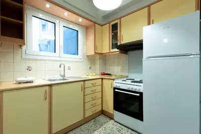 a kitchen with a white refrigerator and a sink at DP Homes Acropolis Promenade in Athens