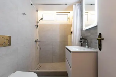 a bathroom with a shower and a toilet and a sink at DP Homes Acropolis Promenade in Athens