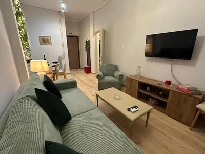 a living room with a couch and a flat screen tv at Upper Kypseli Nest Apartment in Athens