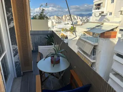 a balcony with a table and a plant on it at Upper Kypseli Nest Apartment in Athens