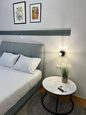 a bedroom with a bed with a table next to it at Star Modern Apartment Kipseli in Athens
