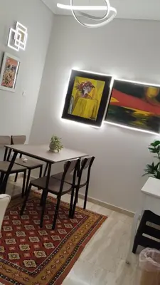 a dining room with a table and some paintings on the wall at Star Modern Apartment Kipseli in Athens