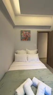 a bedroom with a bed with two towels on it at Modern 2BR Garden Apartment in Faliro Sleeps 5 in Athens