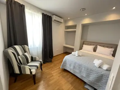a bedroom with a bed and a chair at Ermou 44 - 2bdr apartment in Athens